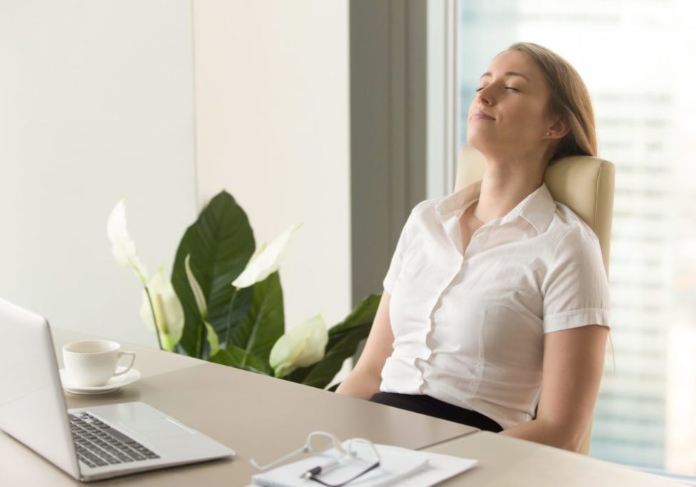 Businesswoman takes short time-out in office work. Beautiful girl lying relaxed on back chair. Female entrepreneur resting at workplace. Comfortable office furniture for long work in sitting position